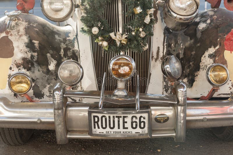 Seligman USA - September 29 2015; Front of tatty vintage car decorated with lights and a Christmas wreath and Get Your Kicks on Route 66 number plate. Seligman USA - September 29 2015; Front of tatty vintage car decorated with lights and a Christmas wreath and Get Your Kicks on Route 66 number plate