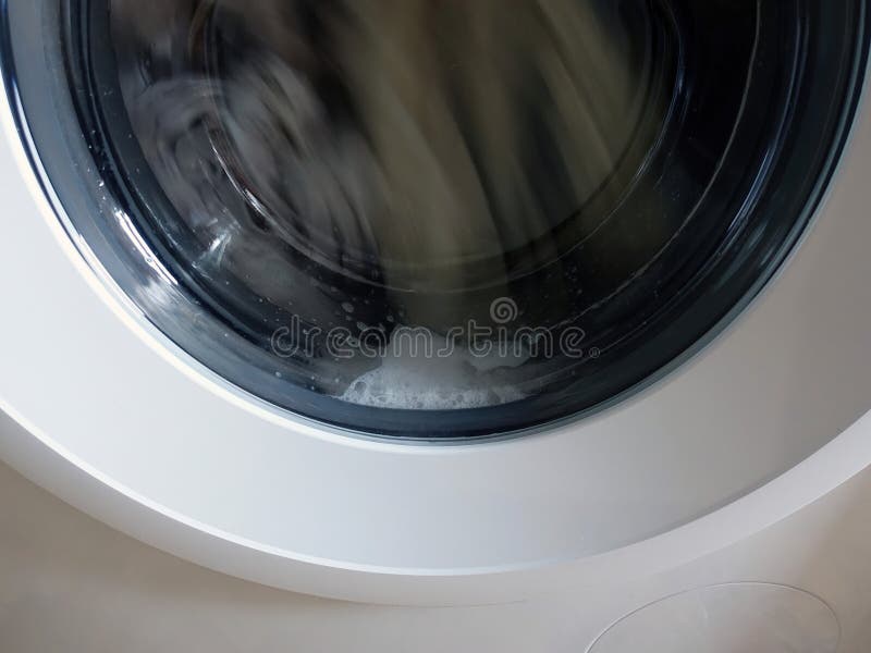 A Front Loading Washing Machine with Soap, Spinning Laundry Clothing