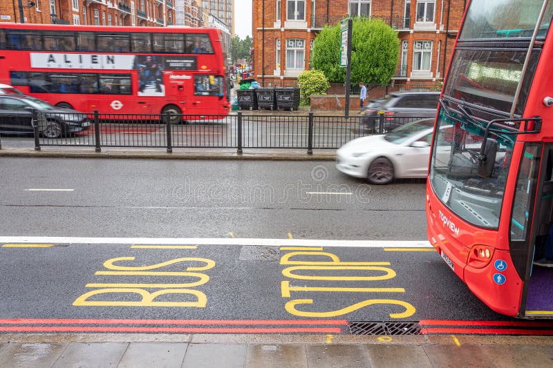 Front part of bus arriving at the stop, written on the ground in yellow letters, stop and bus. London. royalty free stock photography