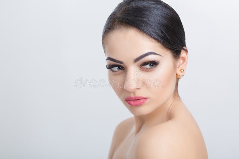 Front portrait of attractive young brunette woman on grey background closeup. girl with clean skin stock photos Front portrait of attractive young brunette woman on grey background closeup. girl with clean skin stock photos