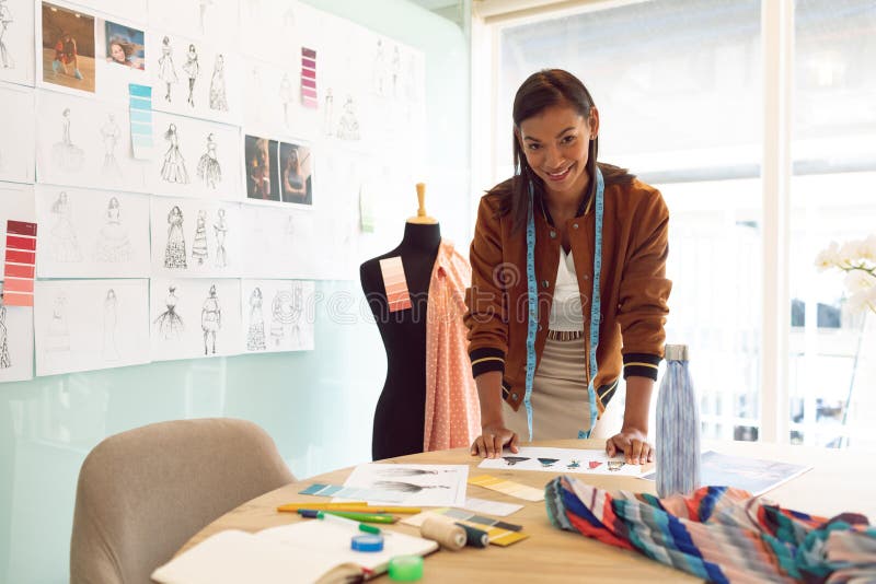 Female Fashion Designer Looking at Camera while Working on Table in a ...