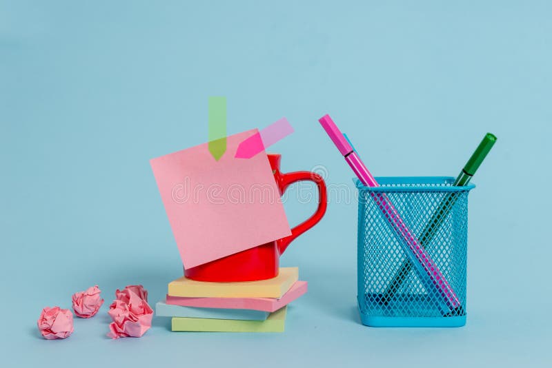 Front view coffee cup colored sticky note arrow banners crushed paper balls stacked pads metal pens holder lying stock photo Front view coffee cup colored sticky note arrow banners crushed paper balls stacked pads metal pens holder lying stock photo