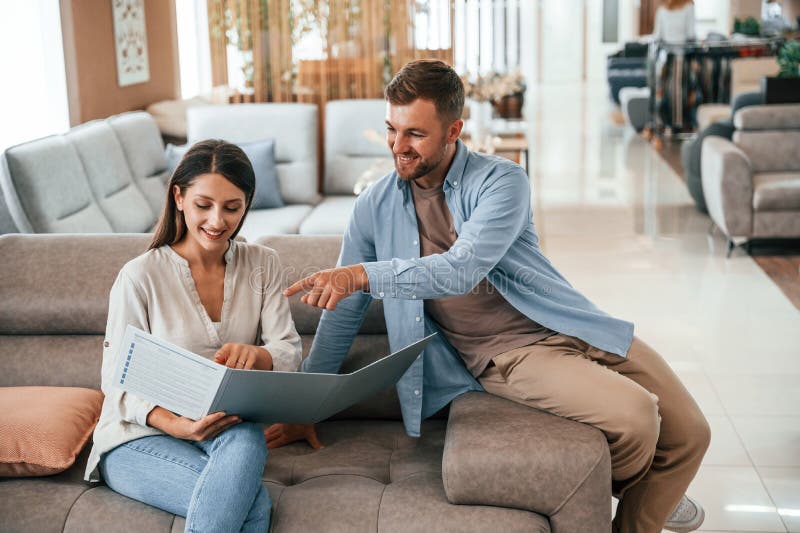 Front View. Couple Choosing the Sofa and Bed in the Store Stock Photo