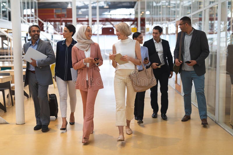 Business people interacting with each other while walking in a modern office