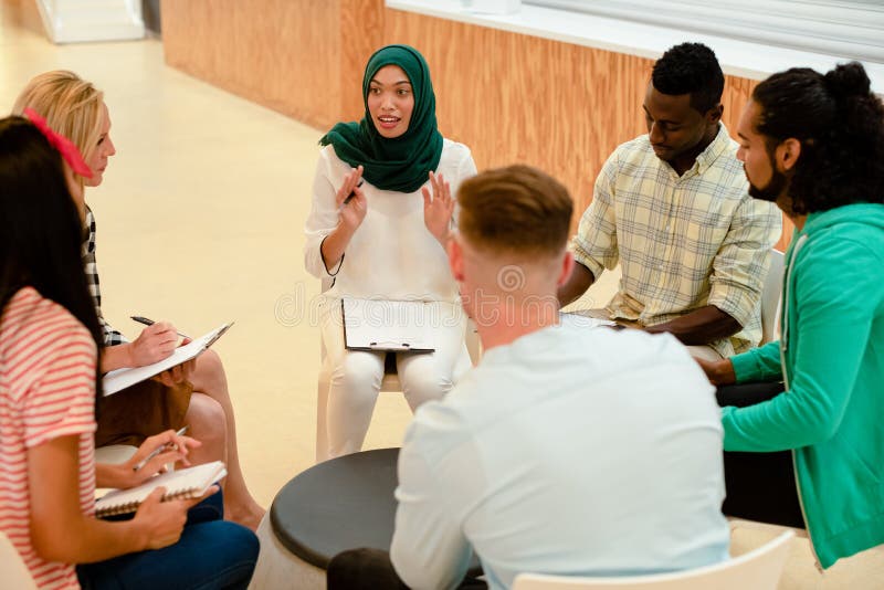 Business people sitting together and having a group discussion in a modern office stock image