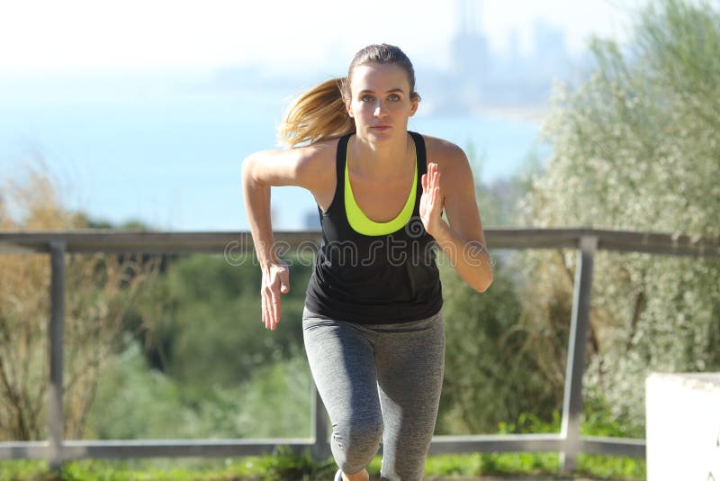 Front view of fast runner woman running towards you royalty free stock photo