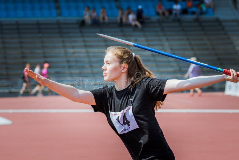 Front view of girl athlete in sportswear throwing javelin stock photo Front view of girl athlete in sportswear throwing javelin stock photo