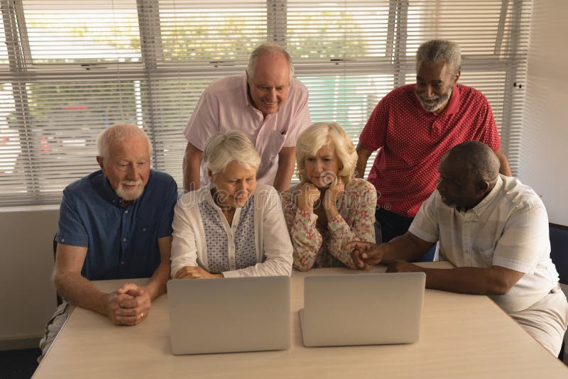 Group Of Senior People Using Laptop At Nursing Home Stock Photo
