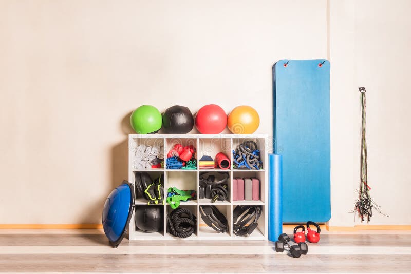 Front View of Gym Equipment Arranged on Shelves on Wall Stock Photo