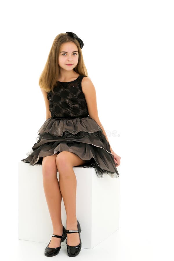 Little Girl Sitting on a White Cube Cross-legged. Stock Photo - Image ...