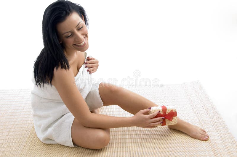 Front view of smiling woman scrubbing her legs