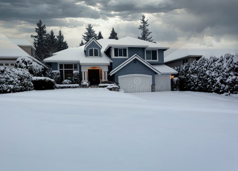 Front view of suburban home with snow storm ending in early morning light stock photography
