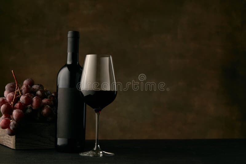 Front view of tasty fruit plate with the wine bottle on dark studio background