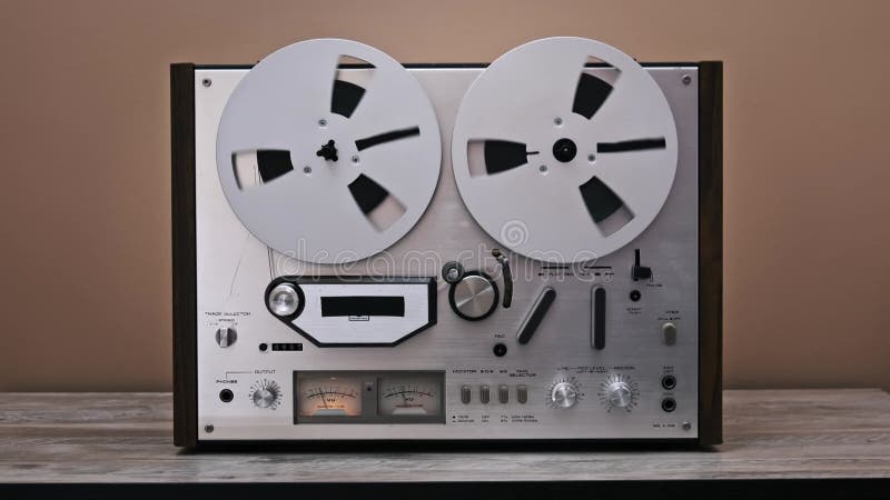 Front view of a vintage reel-to-reel tape recorder on a wooden table stock video footage