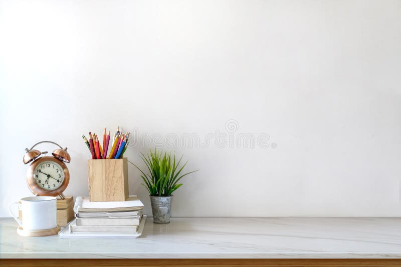 Front view of white desk with coffee mug and house plant. workspace and copy space stock image