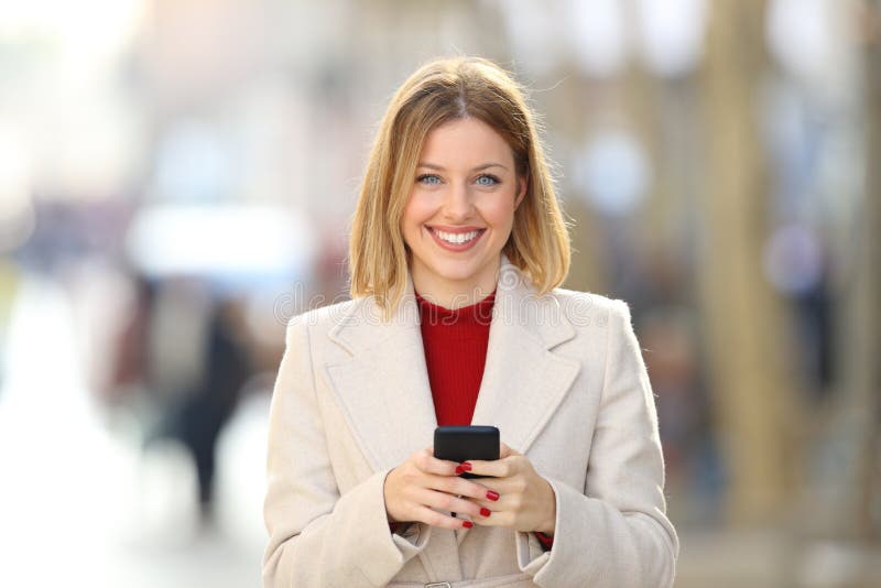 Front view of a woman holding a phone looking at you royalty free stock images Front view of a woman holding a phone looking at you royalty free stock images