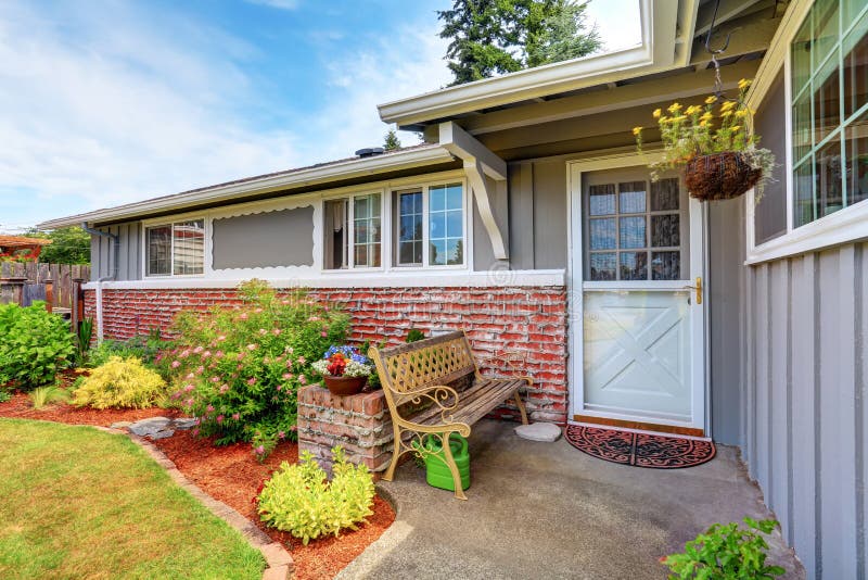 Front white entry door with well kept garden around