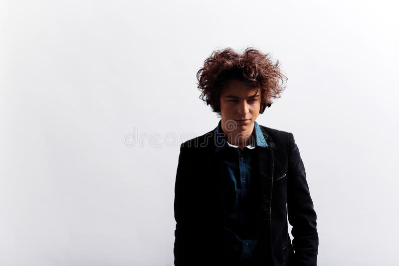 Portrait of frowning, sad young man with awesome hairdo, with headphones, looking pensive, isolated on white background. royalty free stock images Portrait of frowning, sad young man with awesome hairdo, with headphones, looking pensive, isolated on white background. royalty free stock images