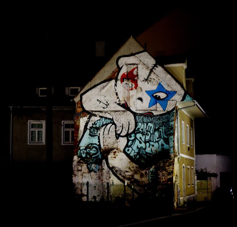 Frontale mening van een stedelijk huis met een massieve graffiti op het front in een grote stad bij nacht royalty-vrije stock afbeelding Frontale mening van een stedelijk huis met een massieve graffiti op het front in een grote stad bij nacht royalty-vrije stock afbeelding