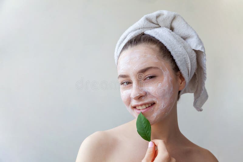 Fronte della donna con la maschera verde della foglia e della crema o di nutrizione fotografia stock Fronte della donna con la maschera verde della foglia e della crema o di nutrizione fotografia stock