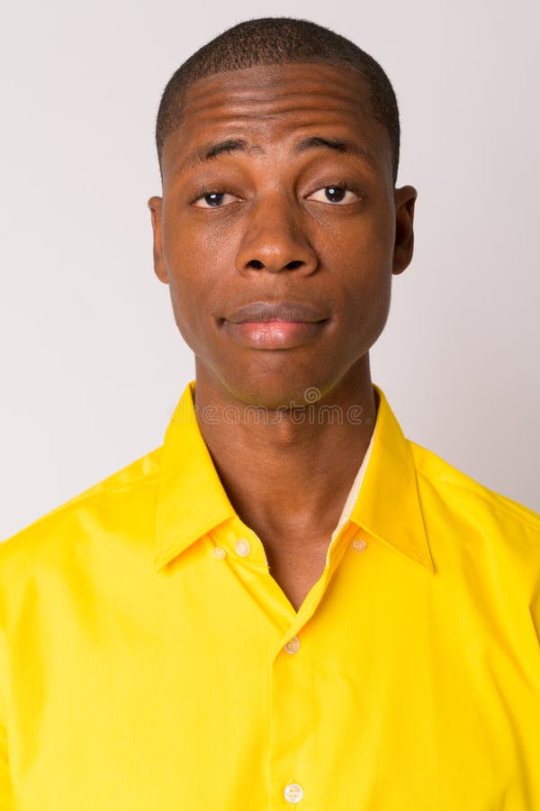 Fronte di giovane uomo d'affari africano calvo bello che porta camicia gialla fotografia stock libera da diritti Fronte di giovane uomo d'affari africano calvo bello che porta camicia gialla fotografia stock libera da diritti