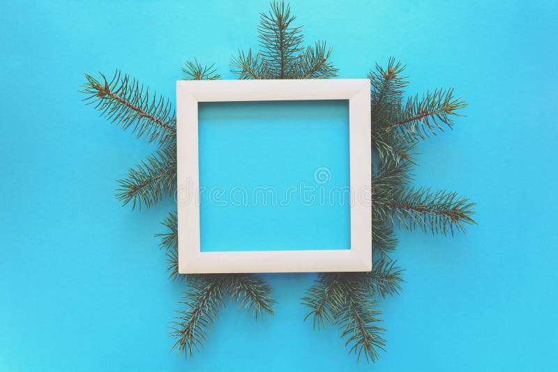 Frontera de la Navidad Ramas de árbol de abeto y marco de madera blanco en fondo del papel azul Visión superior Copie el espacio imagen de archivo libre de regalías Frontera de la Navidad Ramas de árbol de abeto y marco de madera blanco en fondo del papel azul Visión superior Copie el espacio imagen de archivo libre de regalías