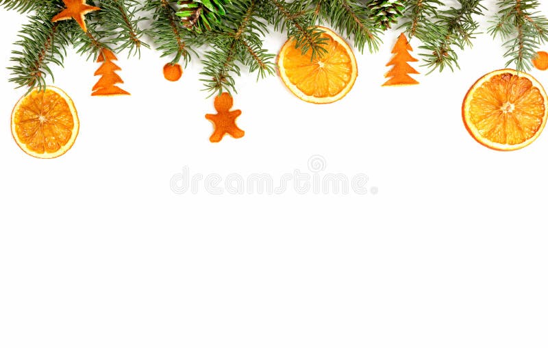 Frontera navideña - ramas de abetos verdes, decoradas con naranjas secas, conos pintados y figuritas de naranja secas sobre foto de archivo libre de regalías Frontera navideña - ramas de abetos verdes, decoradas con naranjas secas, conos pintados y figuritas de naranja secas sobre foto de archivo libre de regalías