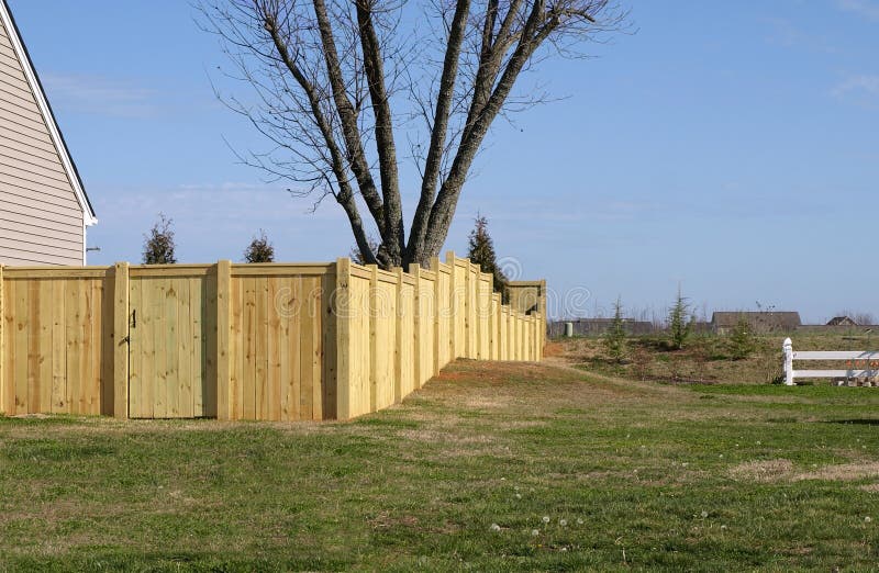 A pine wood fence built on uneven property. A pine wood fence built on uneven property