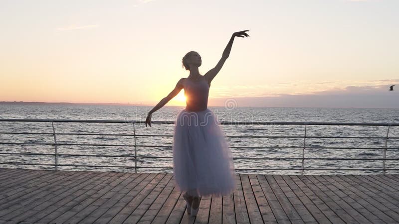 Frontowy widok caucasian piękny dziewczyna tancerz wykonuje elementy klasycznego baleta pozycja wewnątrz stać na czele morze dale
