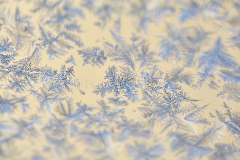 Frost Patterns: Abstract Ice Formations on a Window. Detailed shot highlighting the contrast between the frosty patterns and the royalty free stock photography