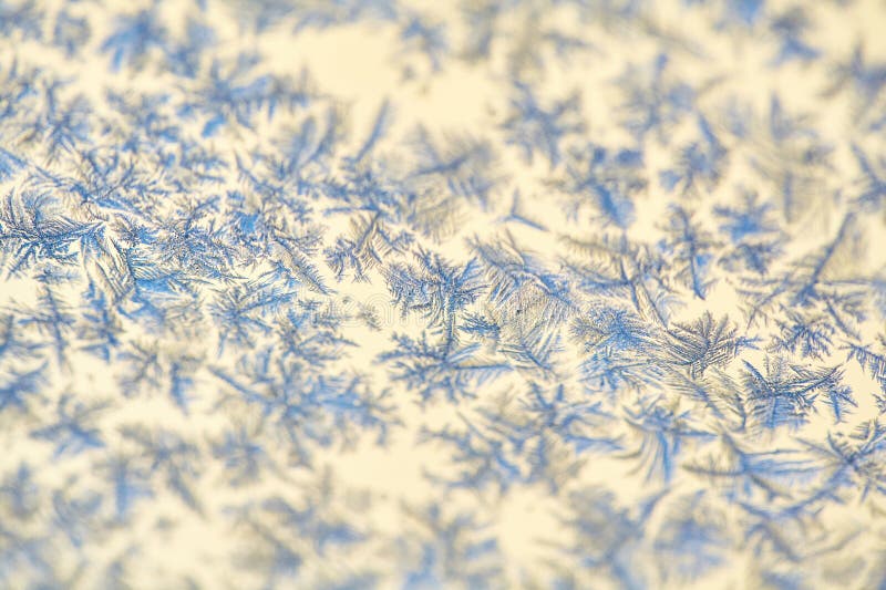 Frost Patterns: Abstract Ice Formations on a Window. Detailed shot highlighting the contrast between the frosty patterns and the stock photo