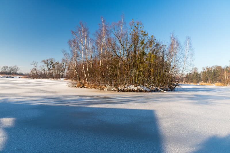 Froster See mit kleiner Insel und klarem Himmel lizenzfreies stockbild Froster See mit kleiner Insel und klarem Himmel lizenzfreies stockbild
