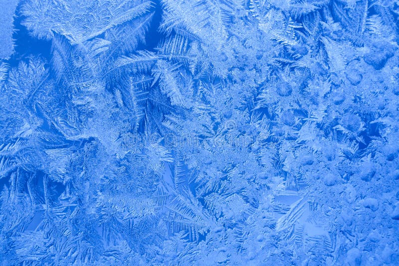 Frosty blue icy pattern on winter window as background.