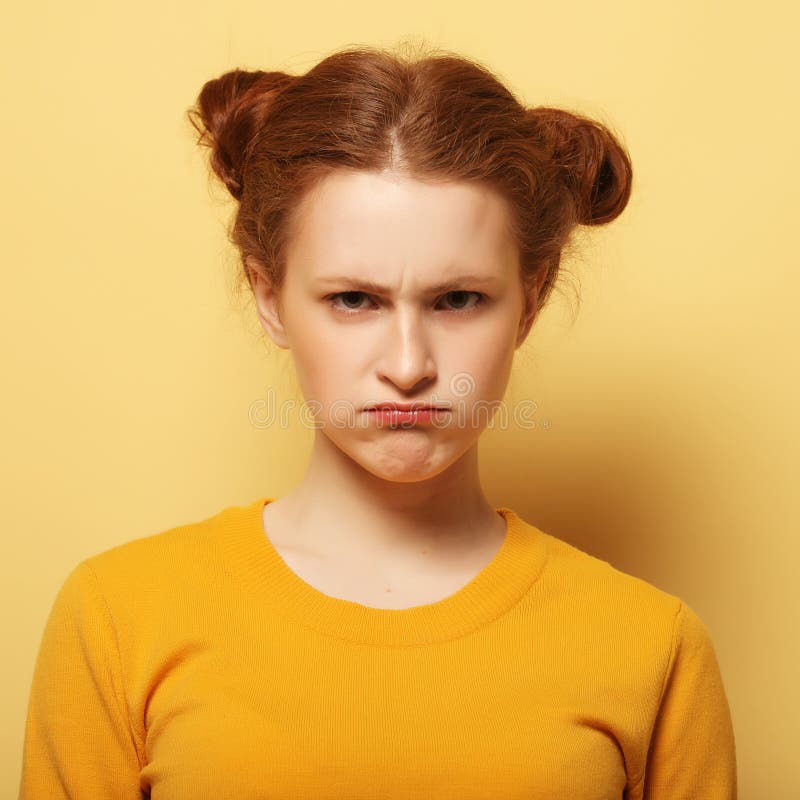 Frowning young woman thinking on yellow background