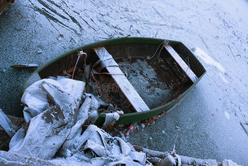 Frozen boat. On a frozen lake with debris Frozen boat. On a frozen lake with debris