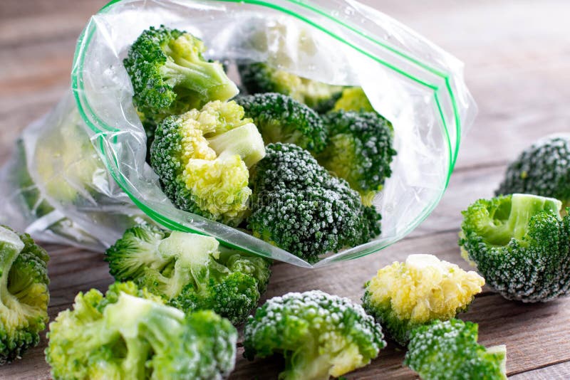 Frozen Broccoli in a Plastic Bag on Wooden Table. Selective Focus Stock