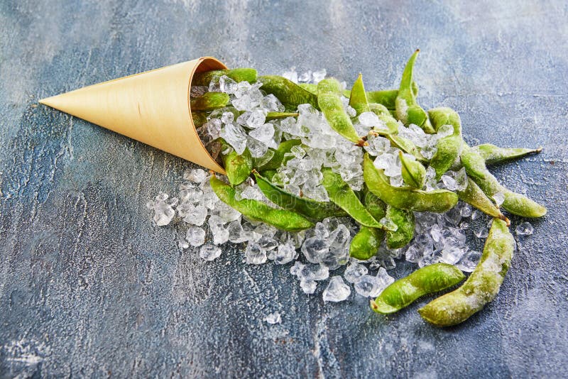 Frozen Edamame or Soybeans in the Mix with Crushed Ice on a Blue