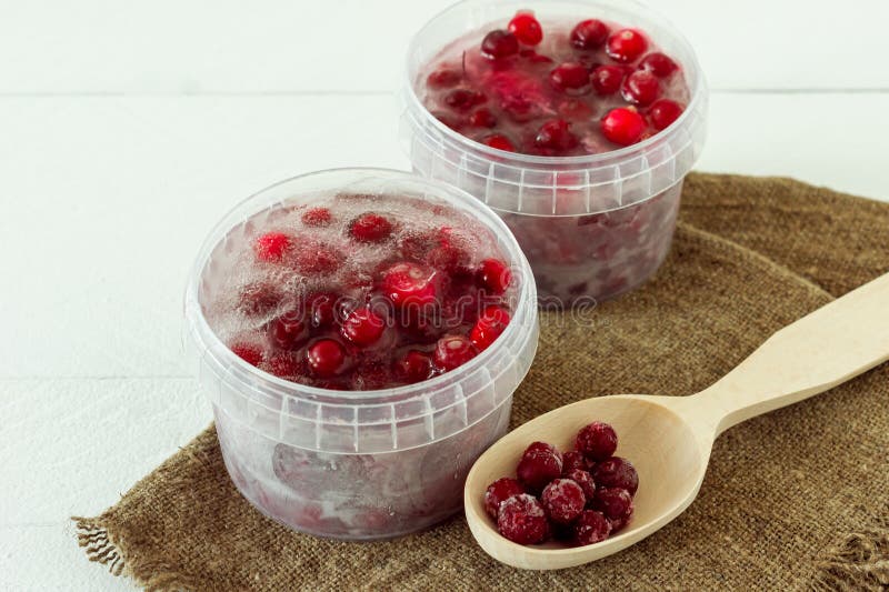 Frozen Healthy Cranberries in a Plastic Containers with Cube of Ice on