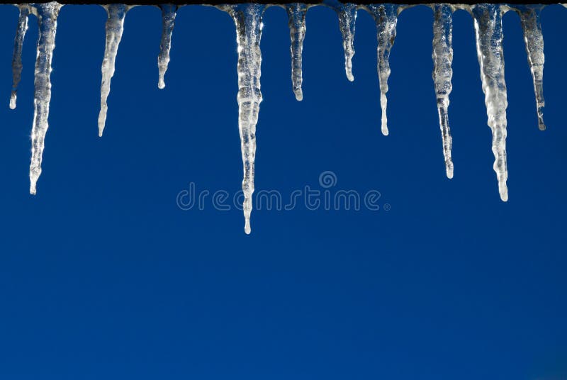 Frozen Icicles on Blue Sky Background