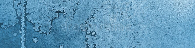 Frozen and misted window glass. Abstract winter banner. Ice crystals and water droplets. Blue tinted natural headline. Misty or