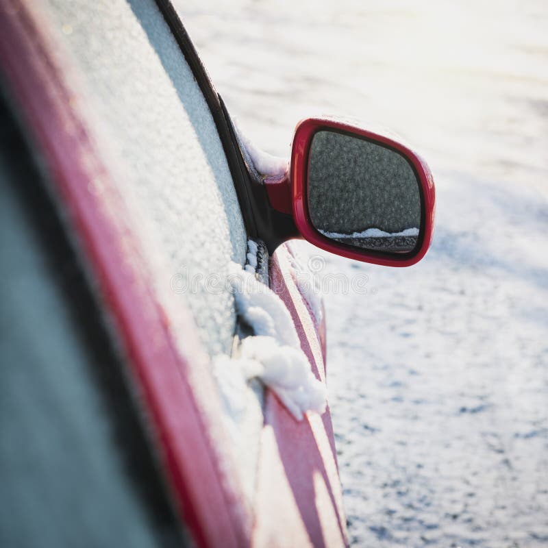 Frozen Red Car Parked Outside, with Focus on Rear View Mirror Stock