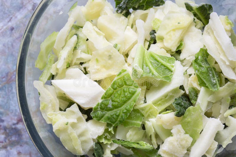 Frozen sliced cabbage defrosting in a glass bowl background backdrop. stock photo