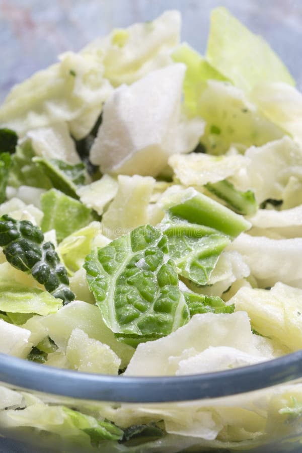 Frozen sliced cabbage defrosting in a glass bowl background backdrop. stock images