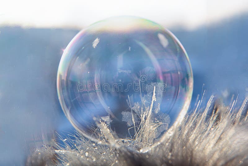 Frozen soap bubble with a beautiful pattern on the snow close-up on a blurry background. Soap snowflake stock images, royalty-free photos and pictures