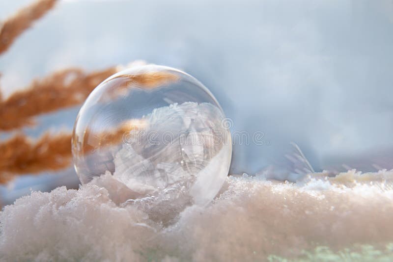 Frozen soap bubble with a beautiful pattern on the snow close-up on a blurry background. Soap snowflake stock images, royalty-free photos and pictures