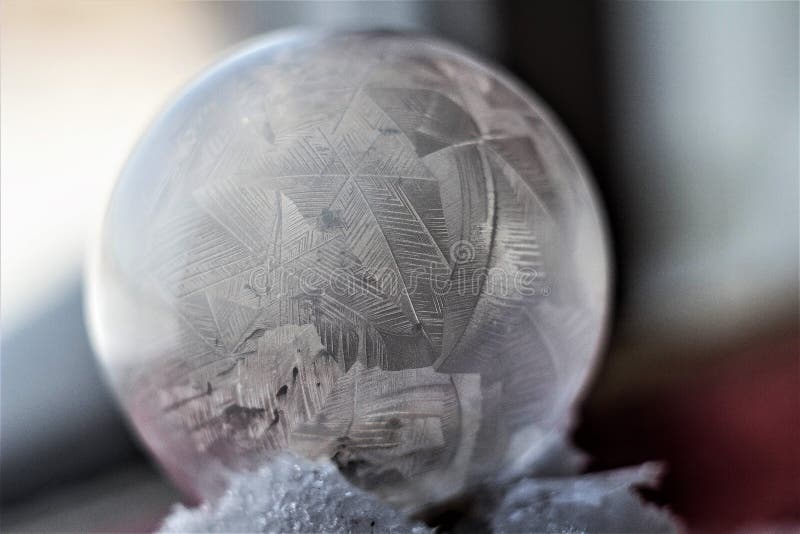Frozen soap bubble through a straw blows a soap bubble, then it freezes in the cold. Soap snowflake stock images, royalty-free photos and pictures