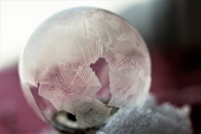 Frozen soap bubble through a straw blows a soap bubble, then it freezes in the cold. Soap snowflake stock images, royalty-free photos and pictures