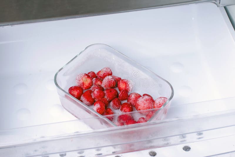 Frozen strawberries in a container in the freezer