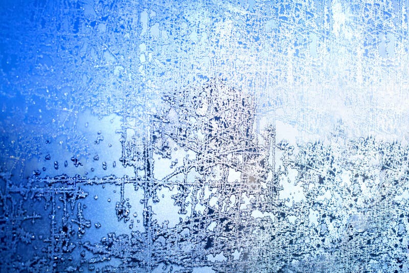 Frozen winter window, glass with frosty patterns, hoarfrost texture, snowflakes, New Year or Christmas ornament for banner