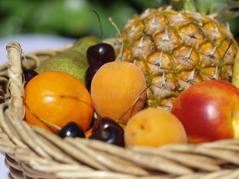Fruit basket with oranges, apples, pineapple, pear and cherries